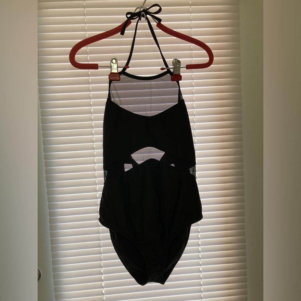 Black one piece halter-tie swimsuit with mesh detailing.